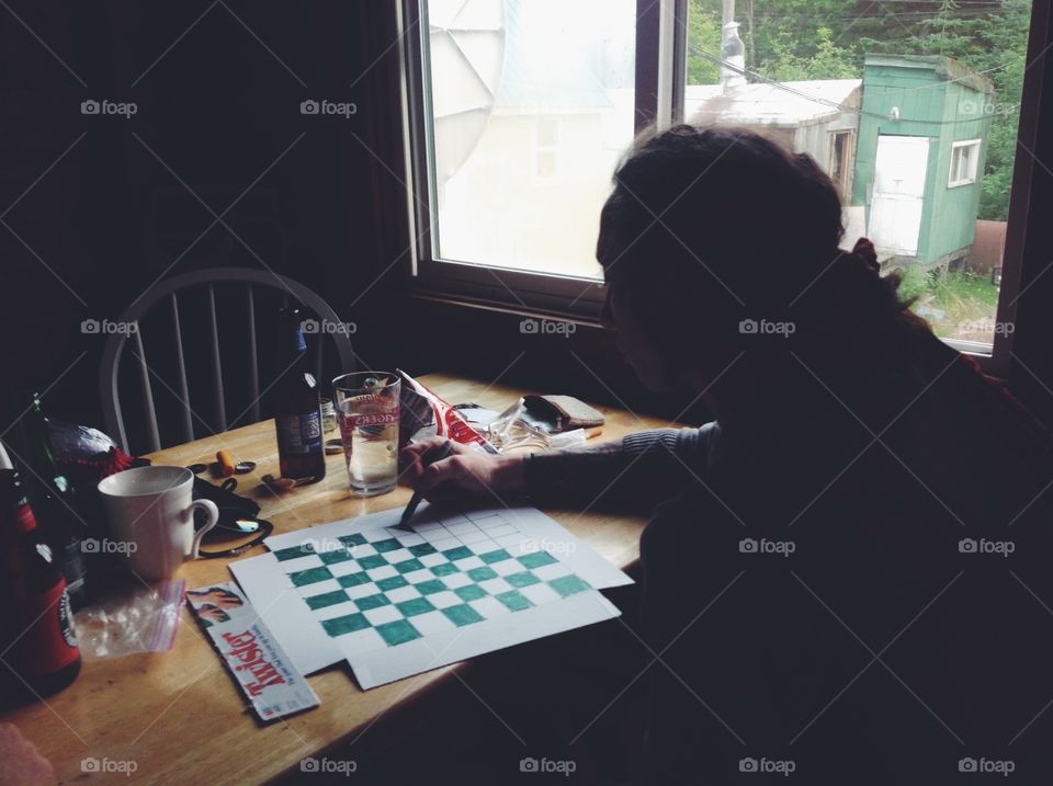 A man is making a chess board out of twister box