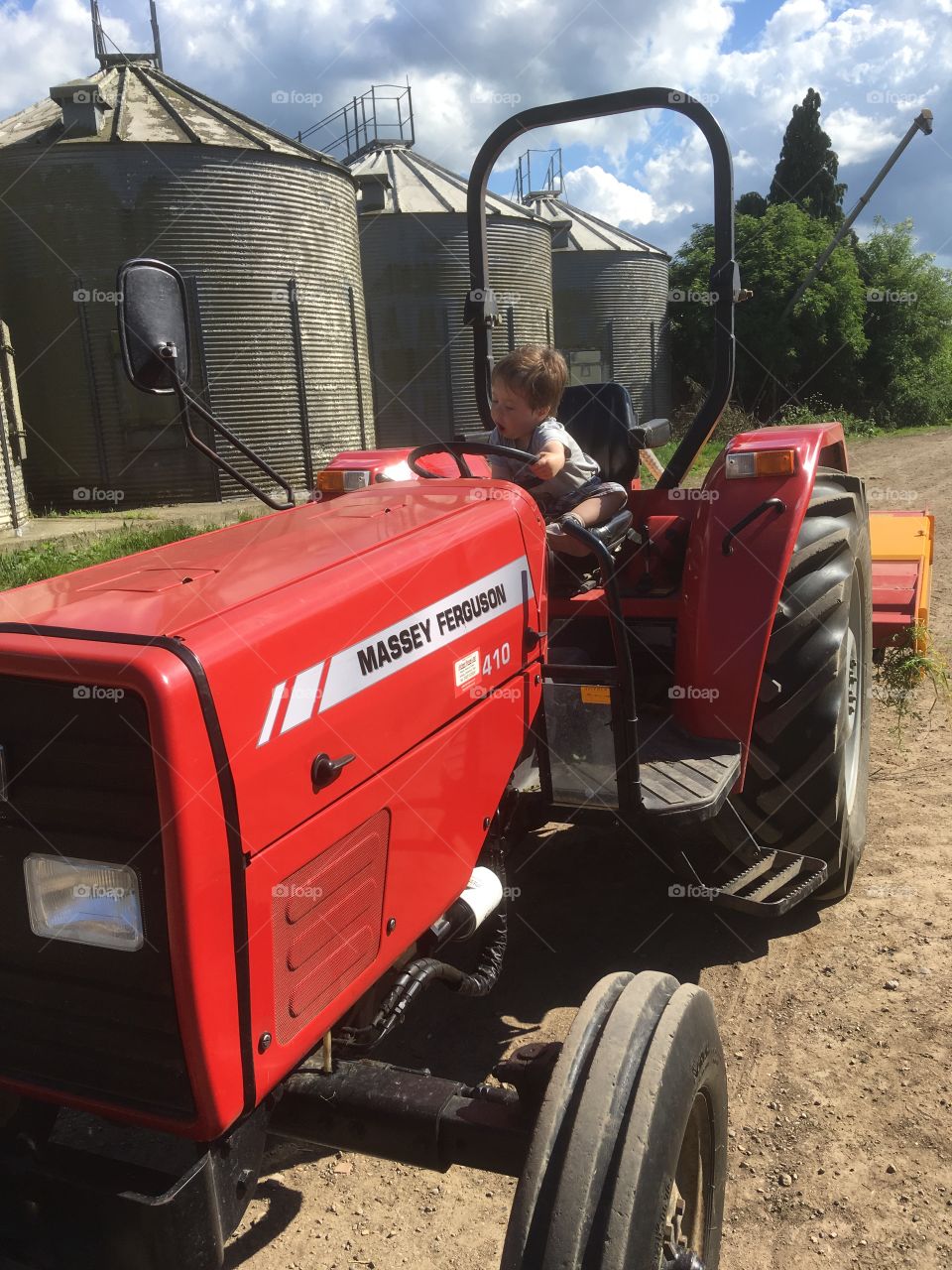 Toddler takes a spin in an old Massey Ferguson tractor in red