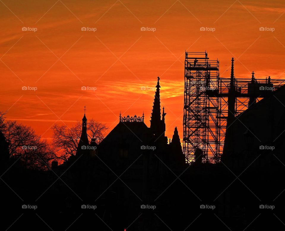 Makes me smile because - A photo of the Cathedral Norte-Dame de Paris with construction scaffolding in the sunset a week before the horrific fire