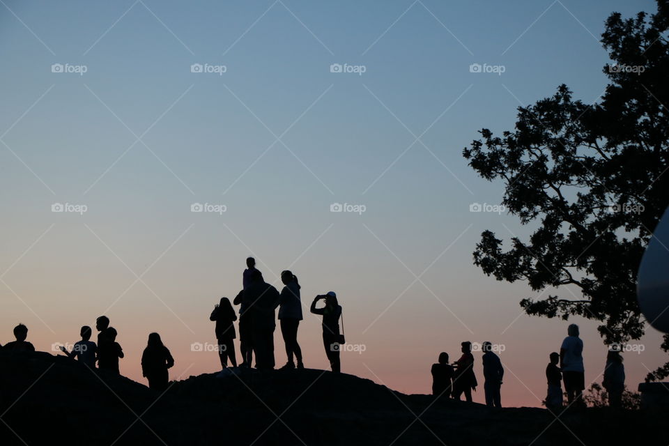 People on the hill watching sunset