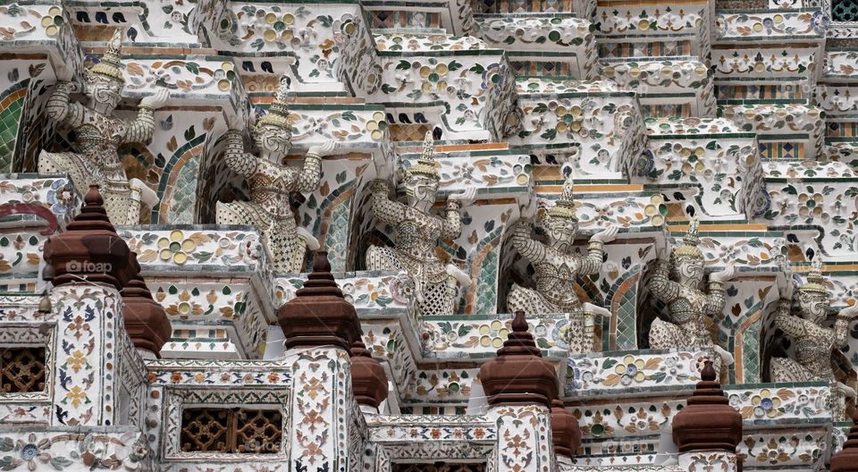 Beautiful Symmetry composition and leading line of Giant statue make the famous pagoda of  Temple of  Dawn (Wat Arun) is very interested for tourists , Bangkok Thailand