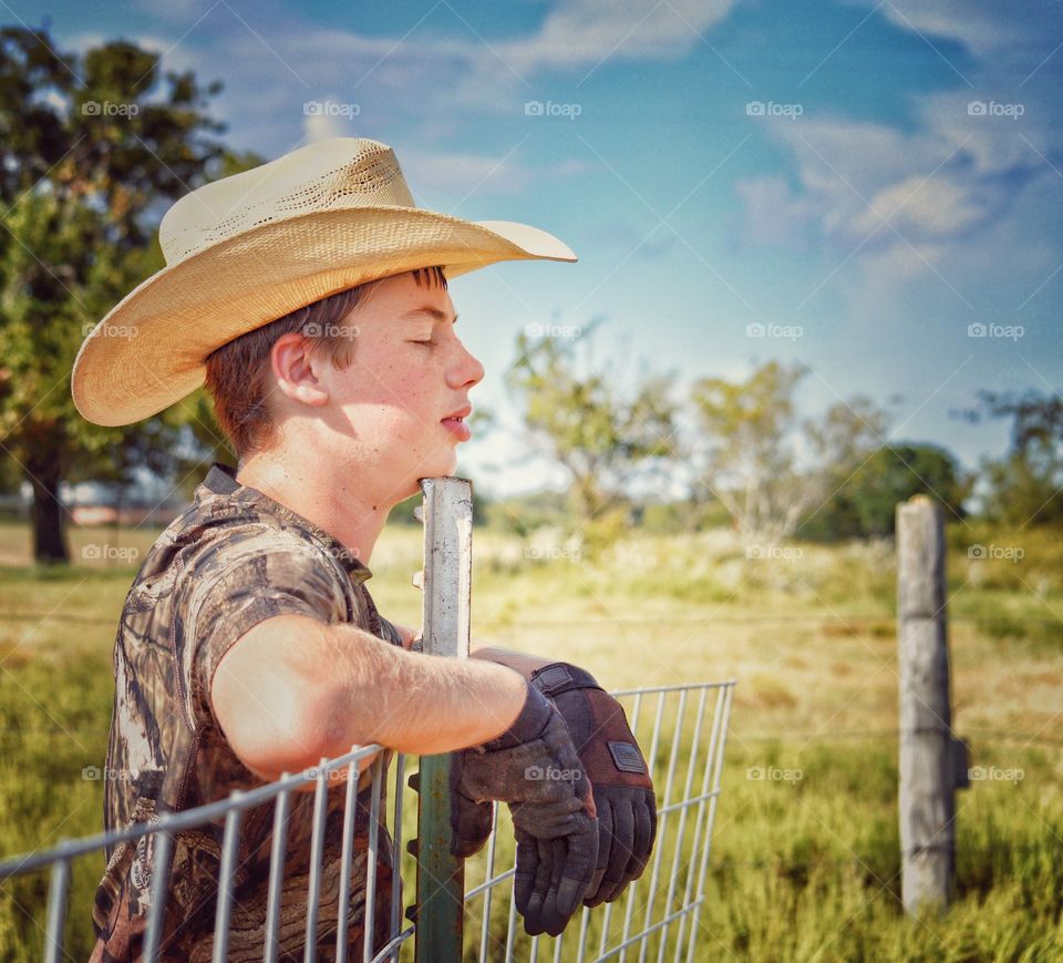 Young boy leaning on fence