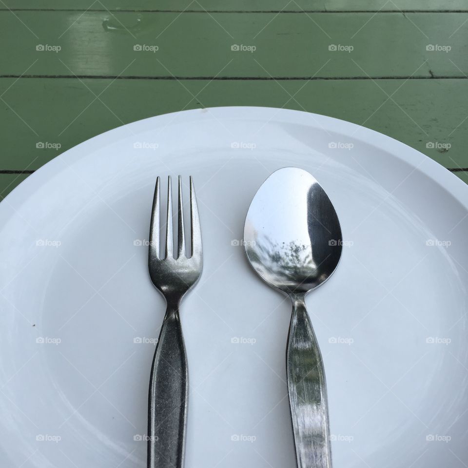 Spoon and fork on white dish, on old wood table great for any use.