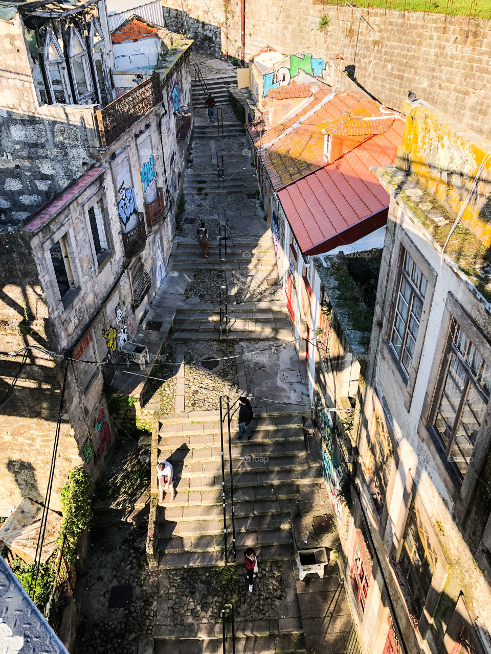 An above view of an old, stepped street in Porto, golden hour is upon us and the shadows are long