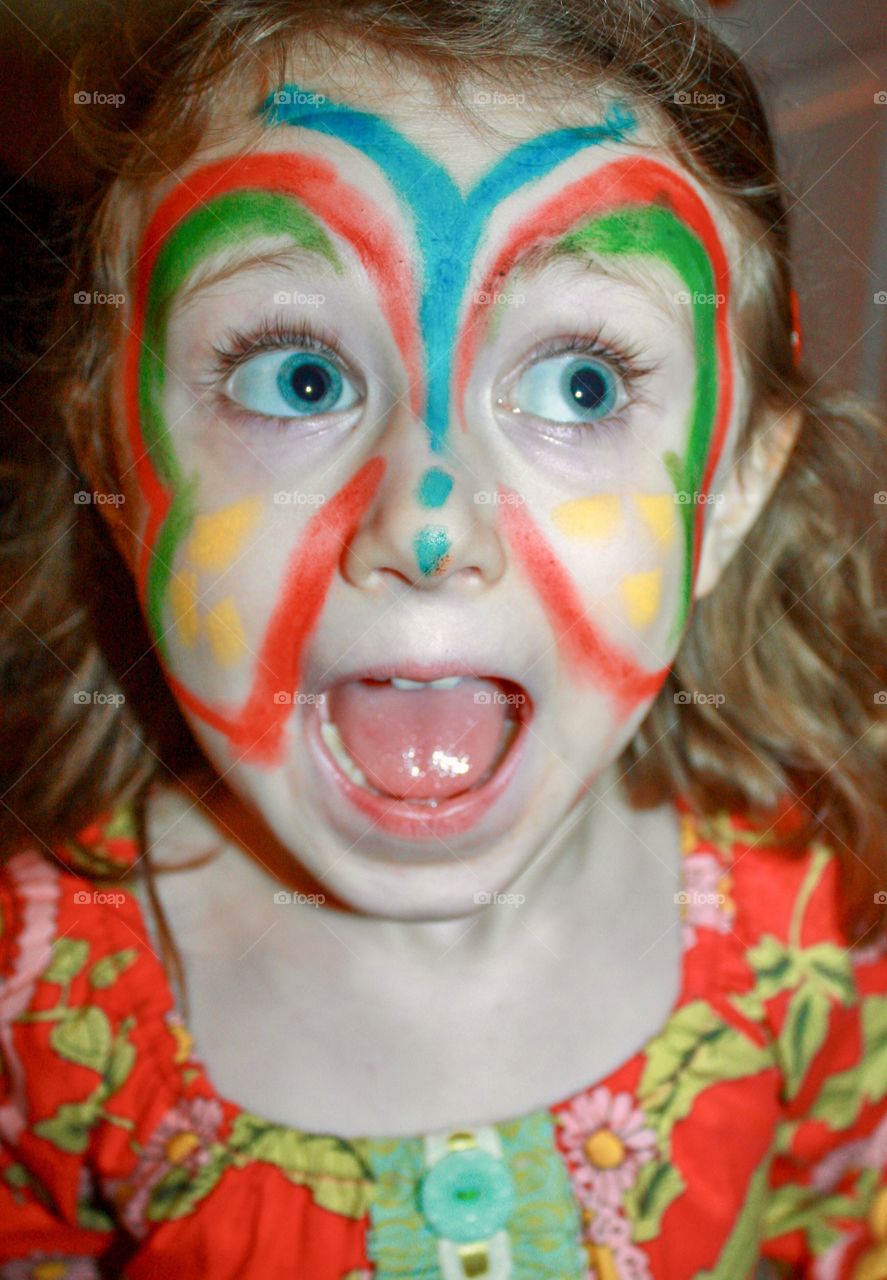 Butterfly face painting on excited happy child