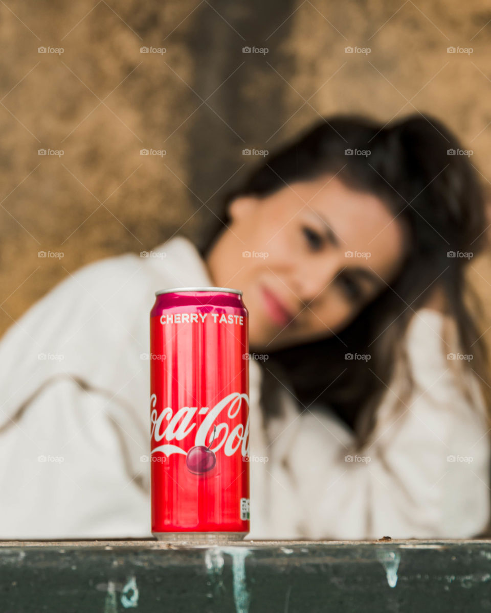 Coca cola with blurred model in background.