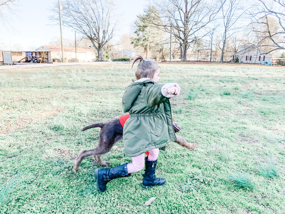 A girl running with her puppy