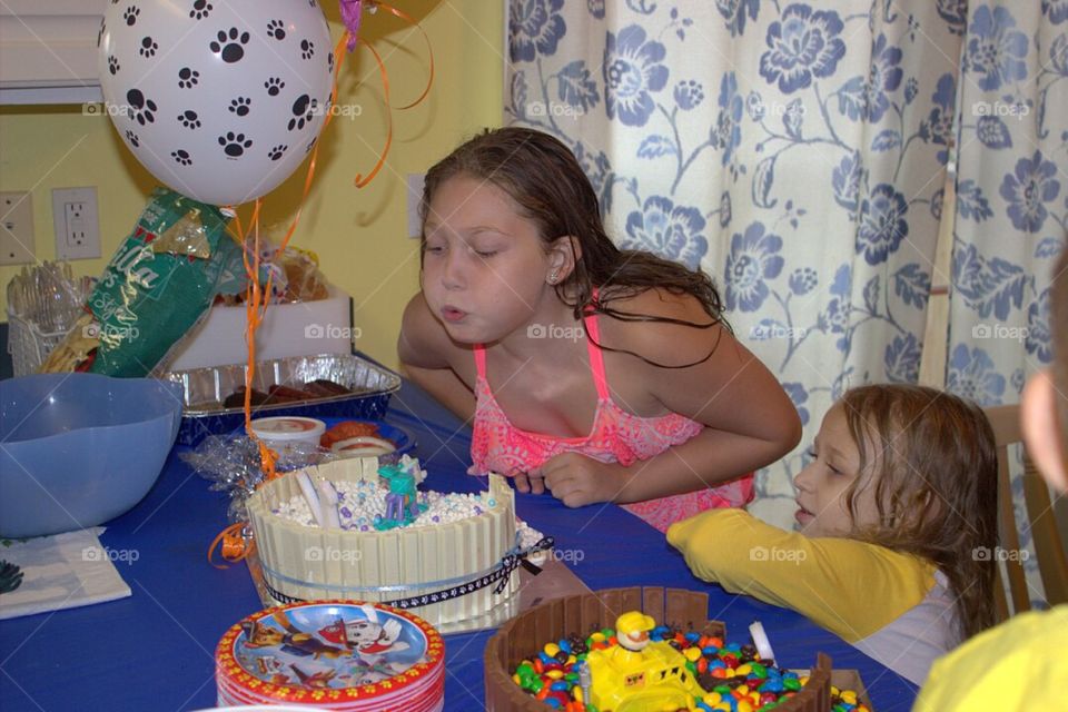 Girl blows out candles on birthday cake