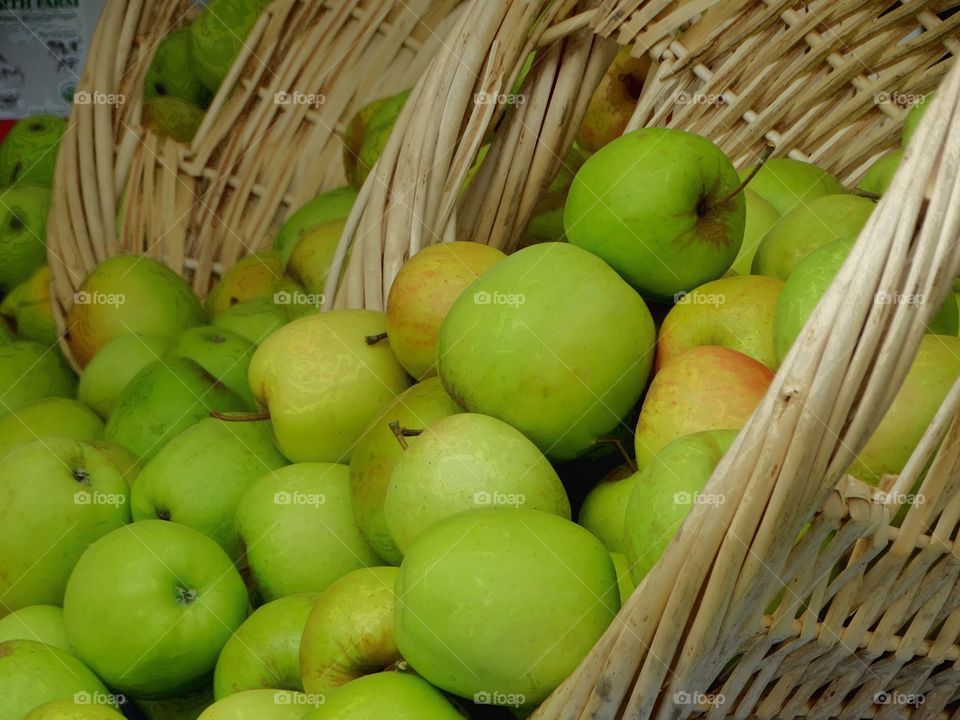 Ripe green apples in wicker basket