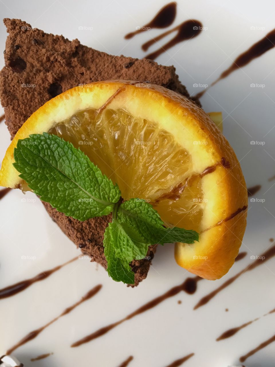 Chocolate cake, decorated slice orange and fresh mint