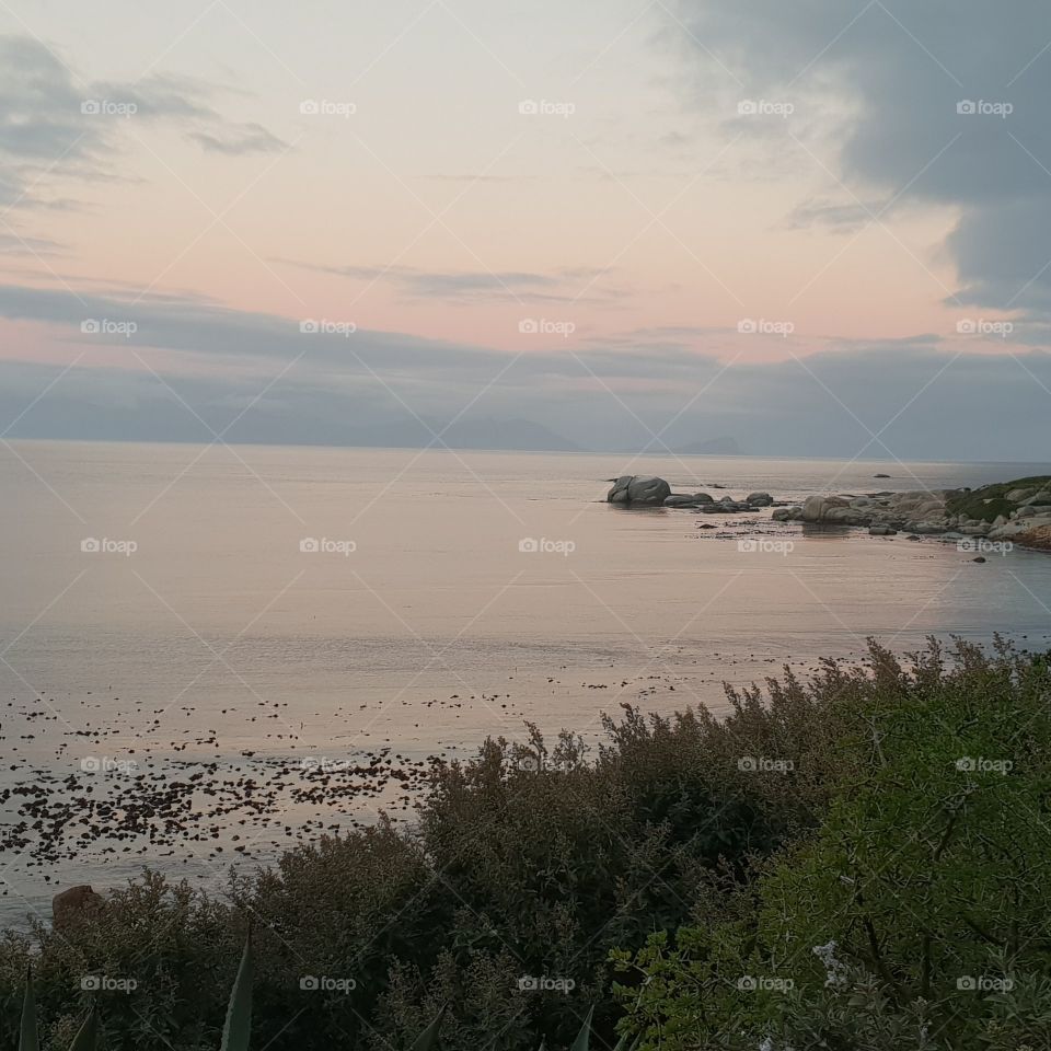 Sun going down provides a peaceful and calm setting on the ocean with beautiful pastel colours on display.