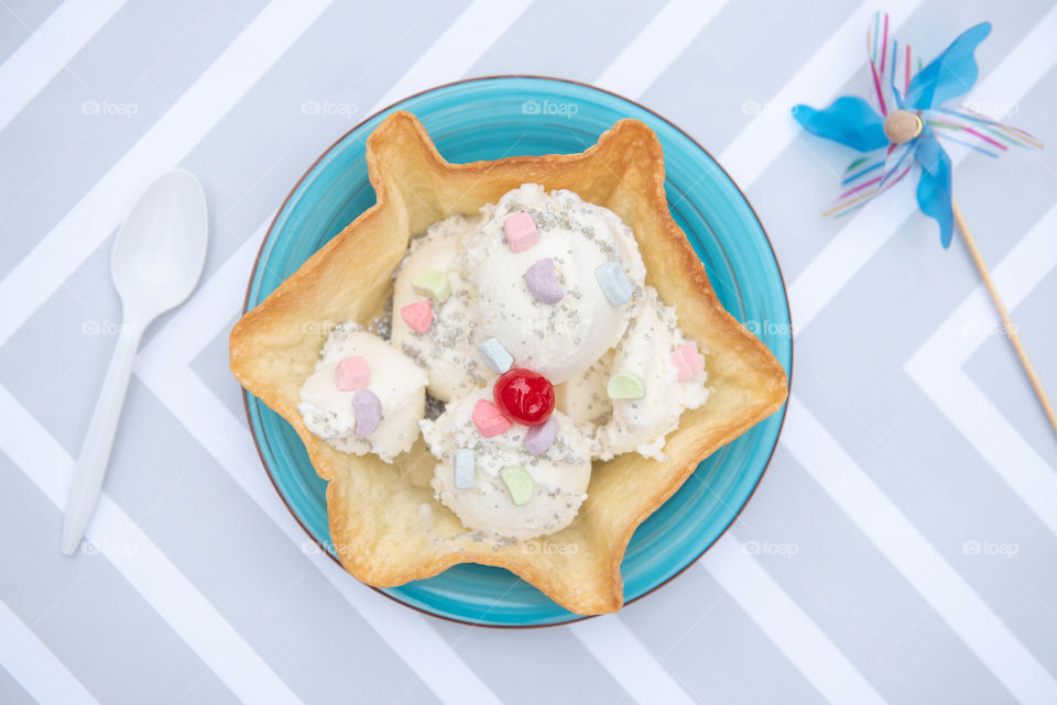 Flat lay of a bright bowl of ice cream and pinwheel