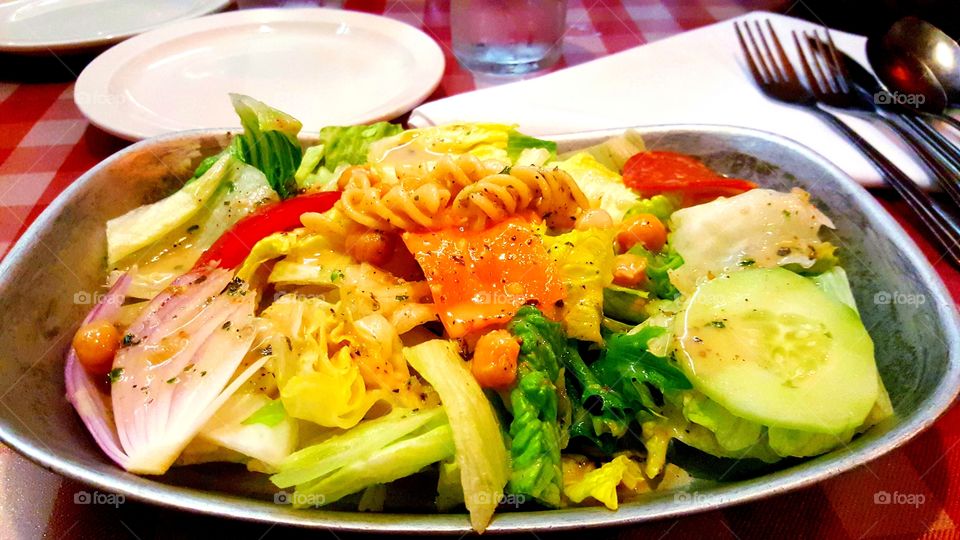 Delicious salad of fresh vegetables, red fish and pasta