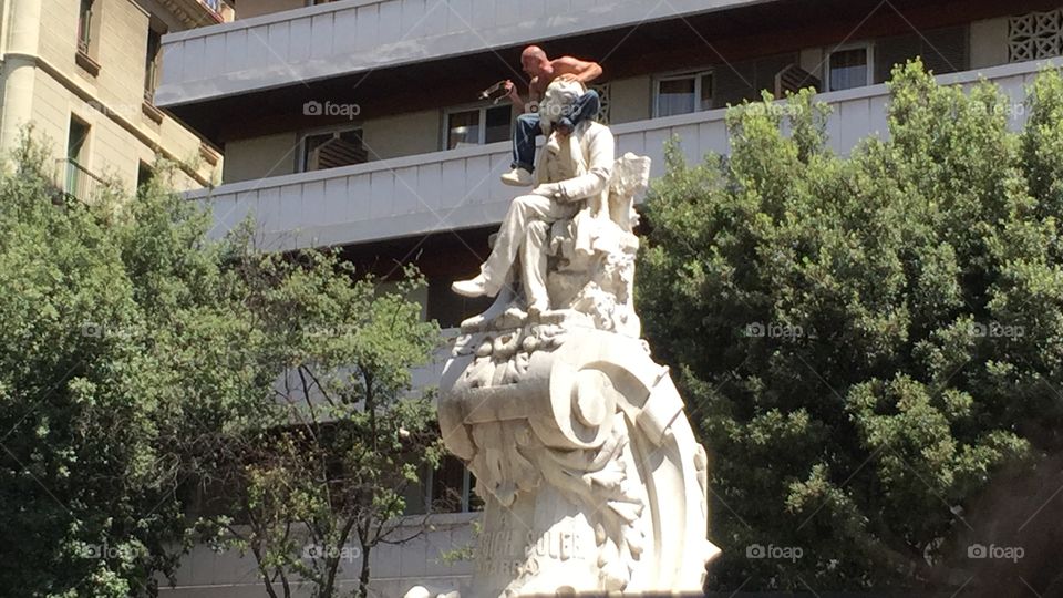 he illegally climbed up the statue in famous Rambla street Barcelona. cops try to rescue but he try to jump
