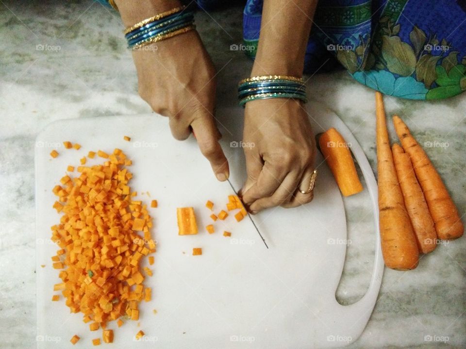 woman chopping carrots with knife