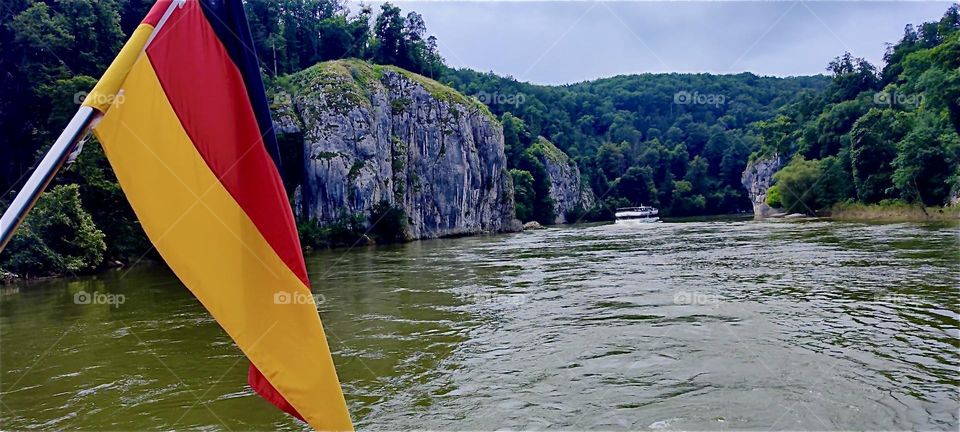 With the German flag hoisted row boats called “Zillen” maneuver along the “Danube” between “Kelheim”, Bavaria and the “Weltenburg Abbey” at the “Donaudurchbruch” or “Danube Gorge”, two sharp turns followed by a half loop. 2024. Hypnotic Productions