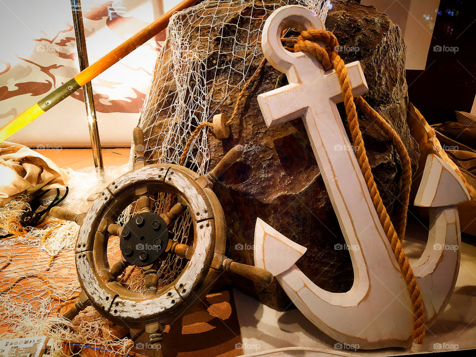 Marine theme.  Stone with a net, wooden anchor and steering wheel