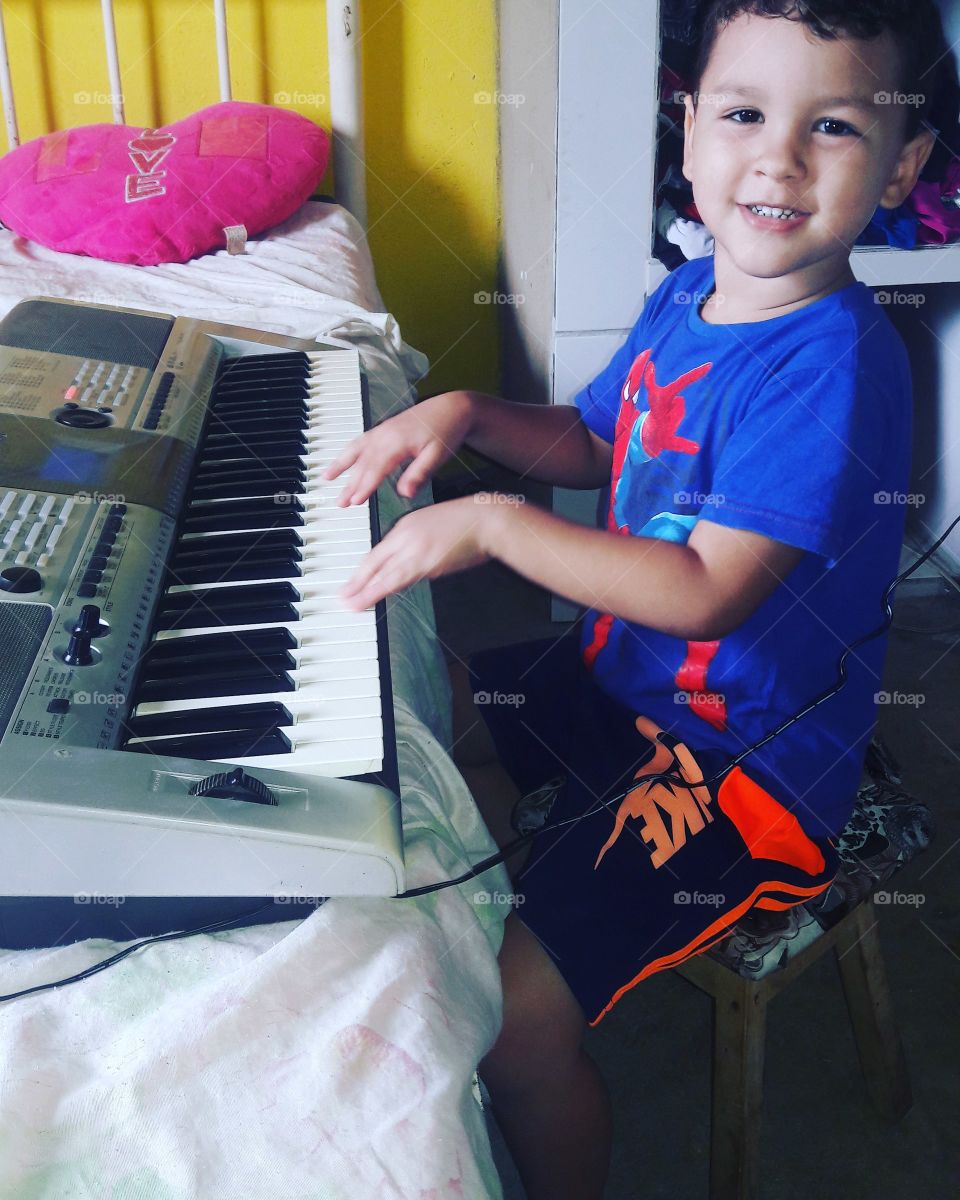 criança tocando teclado