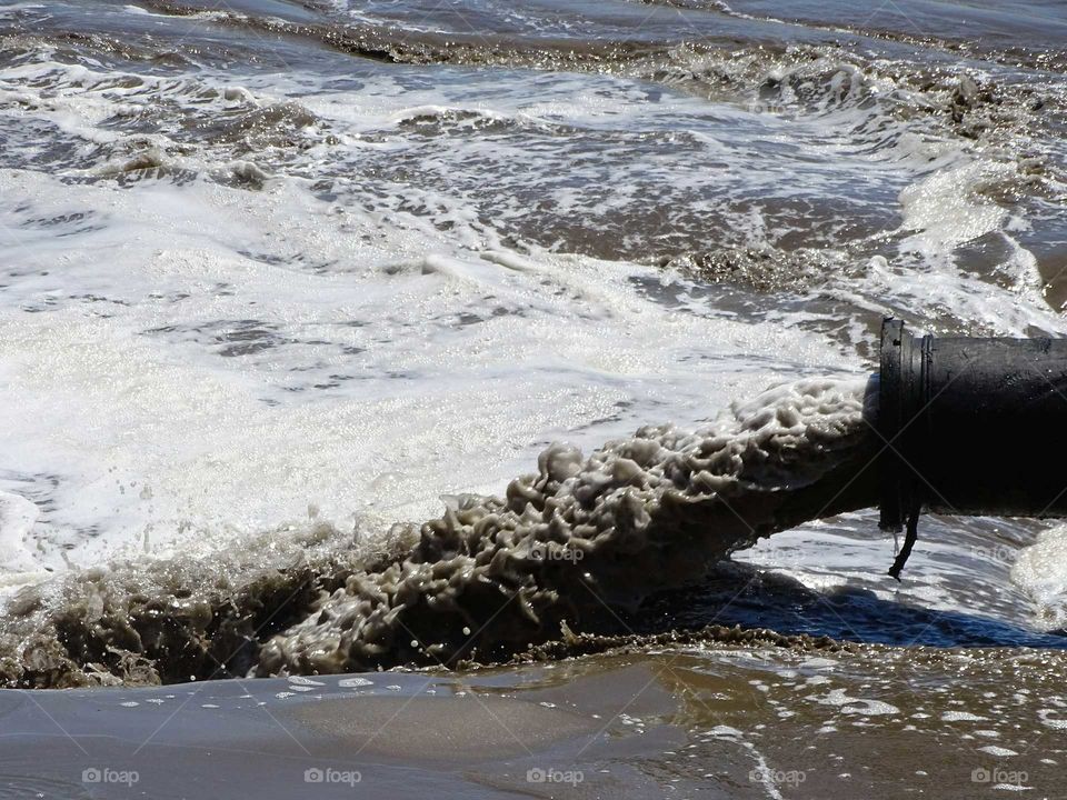 Pumping water and sand on the beach