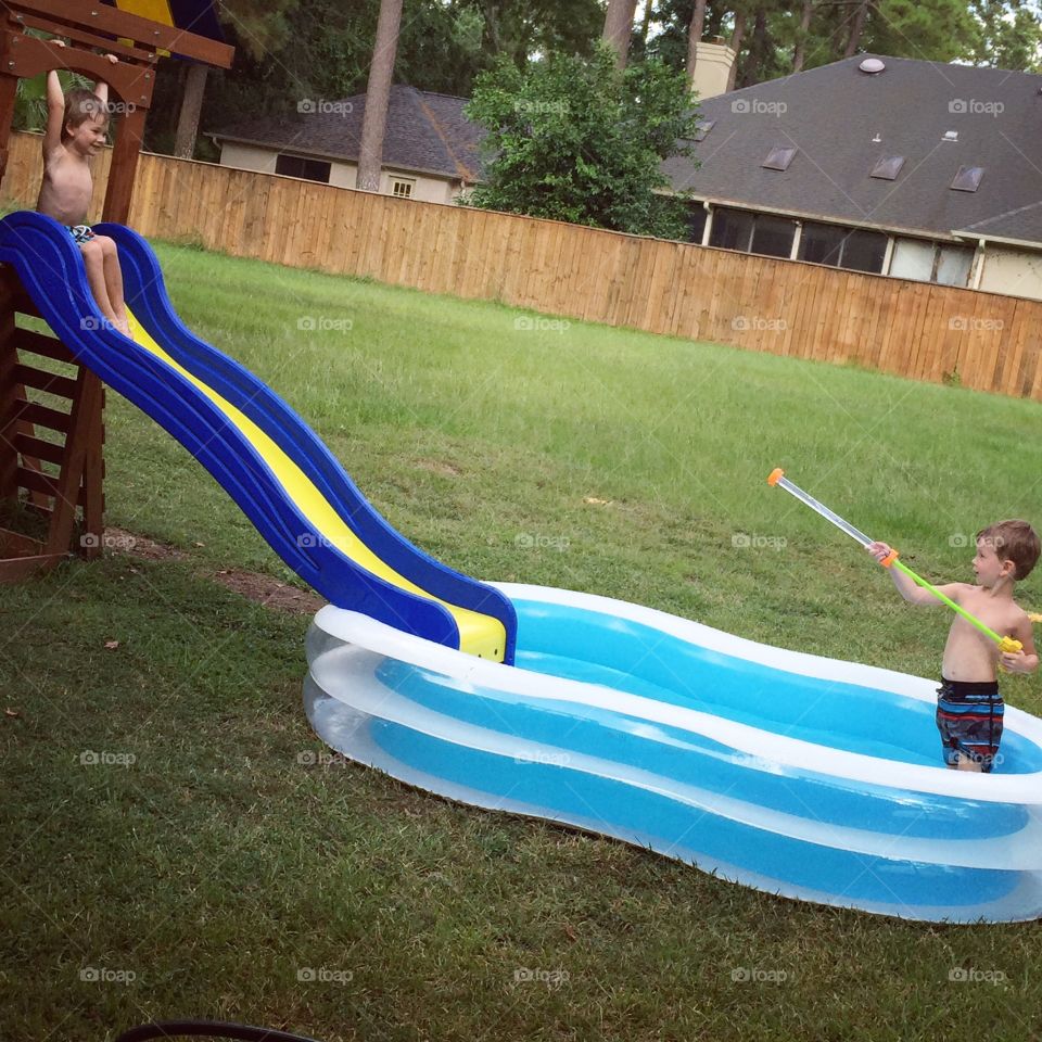 Pooling in the summertime. Just being a little precious monster shooting his brother with a water gun :p