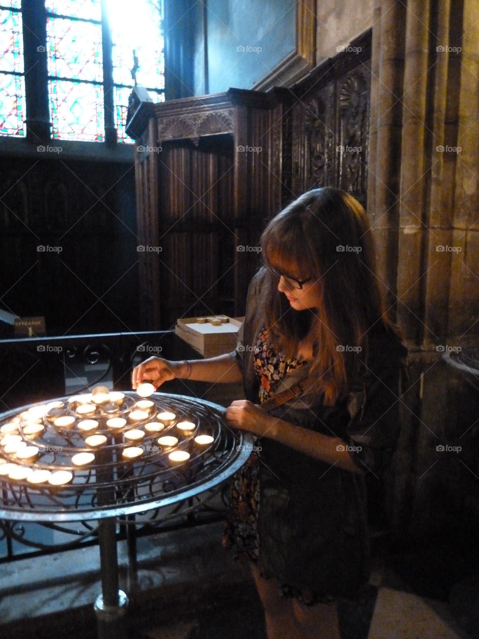 Woman lighting candles in church