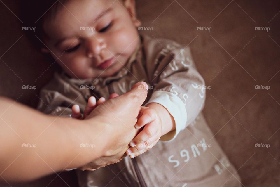 Baby reaching out for hand, hand reaching for baby, precious moments with baby, exploring baby 