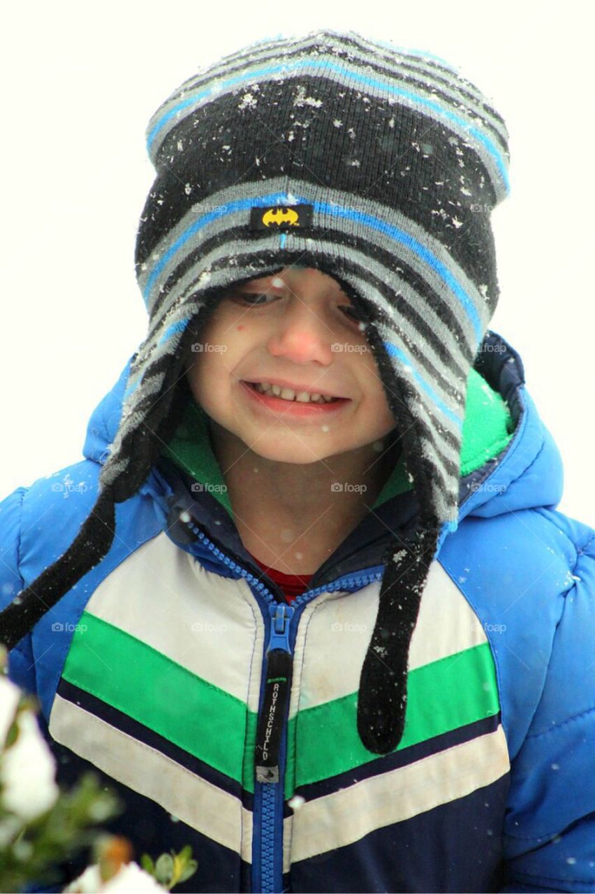 Close-up of boy with snow on cap