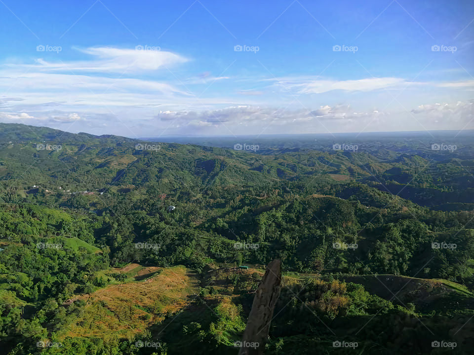 The blue sky in the distance can be seen through the gap of the mountain, it seems that in a natural and heavenly place, standing on the hill, I want to dream of touching the sky.