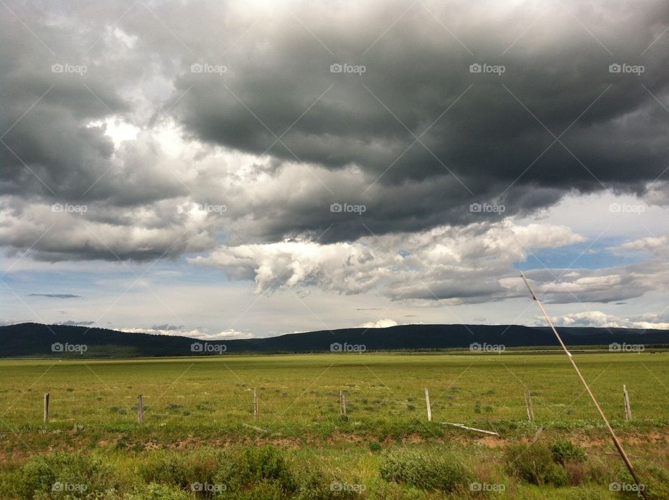 clouds grassland hills. Dark clouds roll over grassland and hills