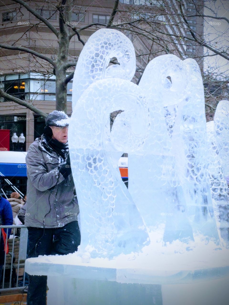 Senior man standing near frosted statue in winter