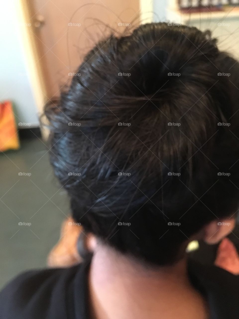 A girl's hair styled in a bun view from behind, from the back