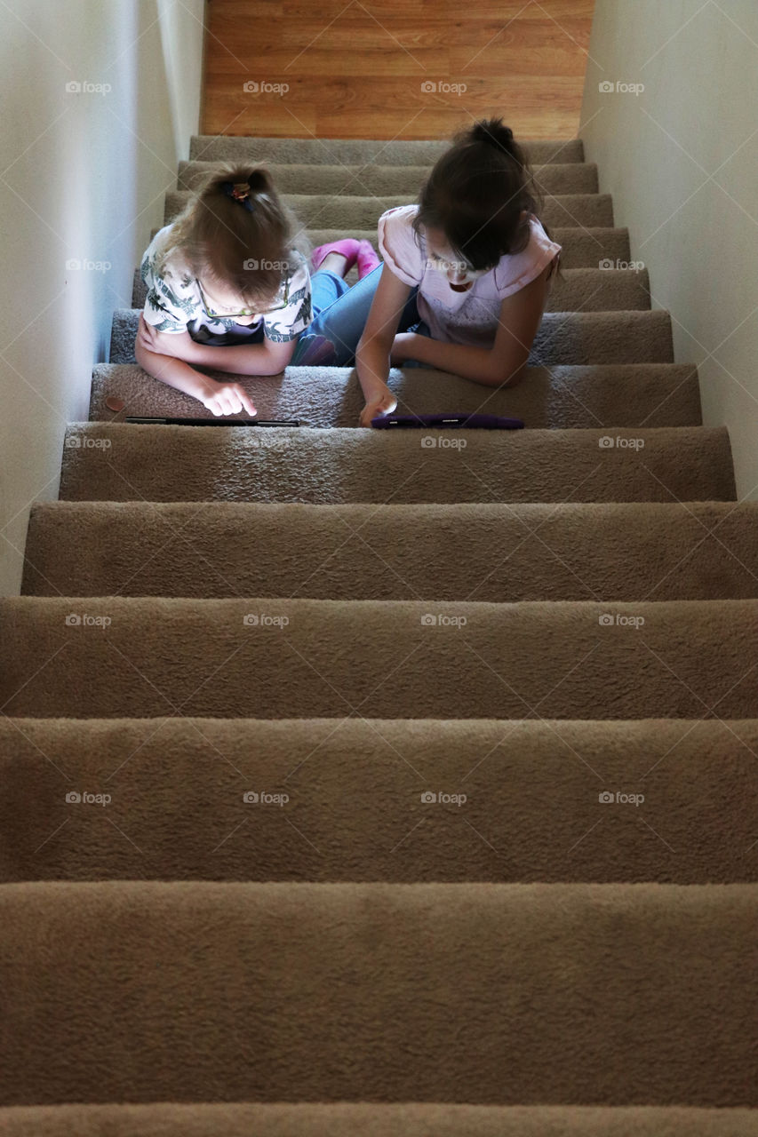 Two girls sitting on stairs