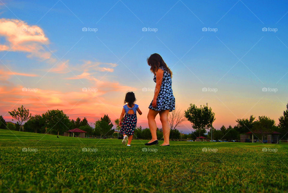 Mother and daughter walking in grass
