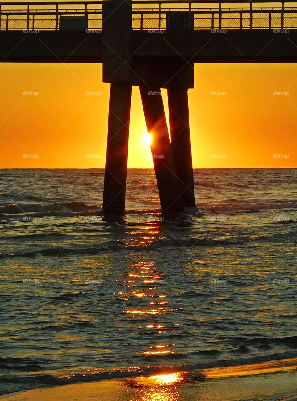 Majestic sunset under the pier - this magnificent sunset was captured at the peak of the sunset as it was descending below the horizon