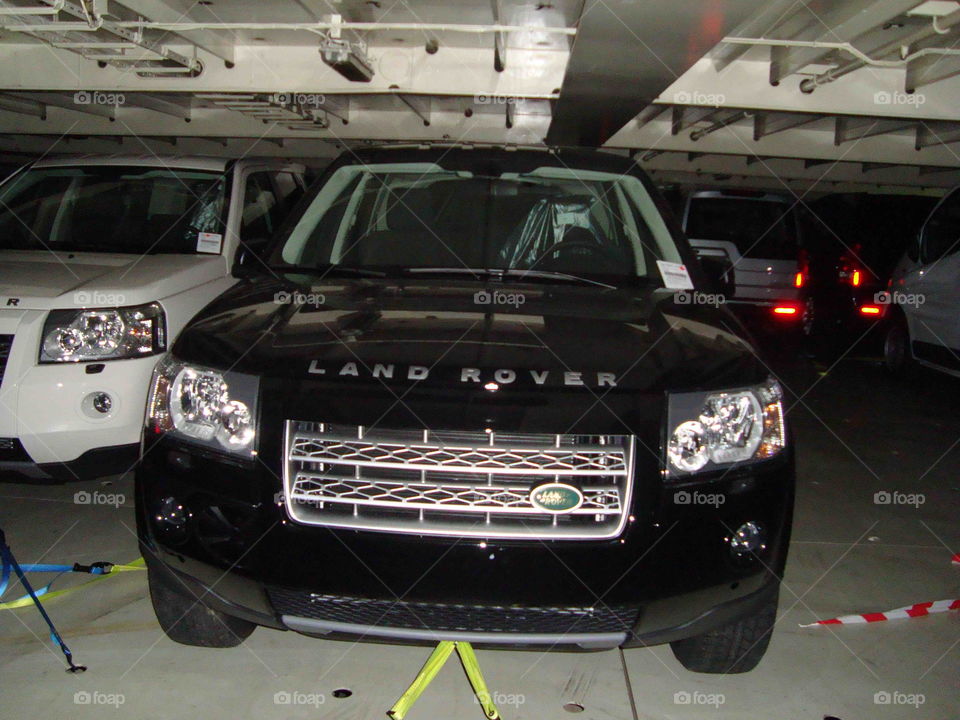 # Land Rover# huge# glassy black# ship's deck# lashed on ship#