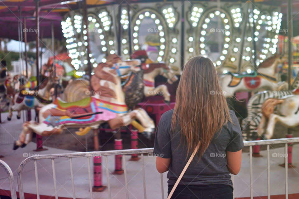 Mary Go Round. Girl standing in front of carnival ride 