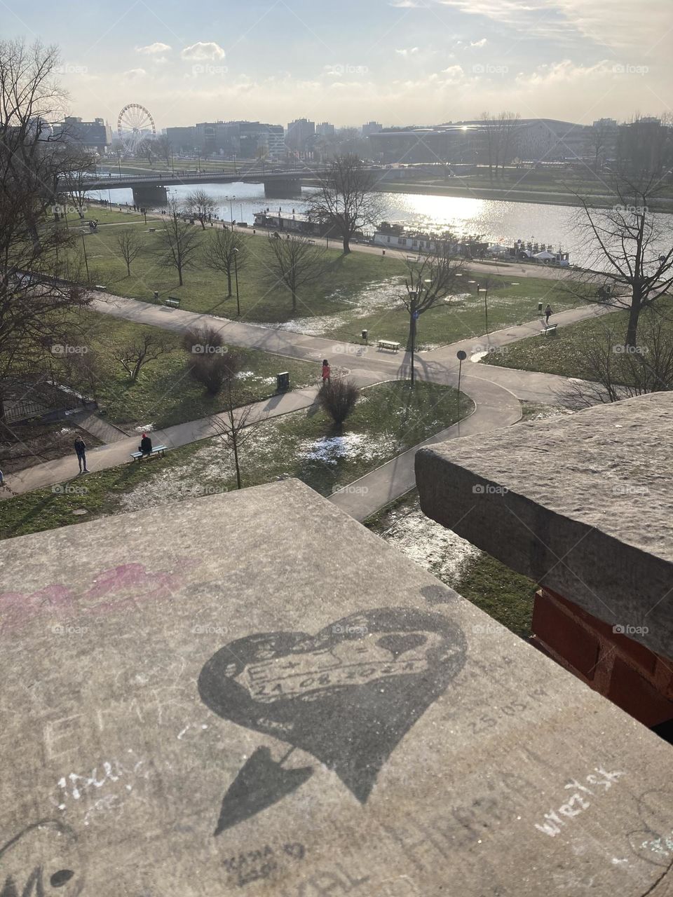 Wisla river before sunset. Heart vision. Love around. Sunny day perfect for sightseeing. Kraków city at night during Christmas time. Famous landmarks and Christmas tree. Sightseeing the city at night. Crowded evening on Christmas market.