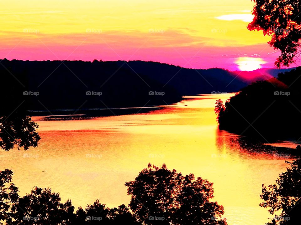 Encapsulating sunset low on the rippled waters of Normandy Lake with glowing colors.