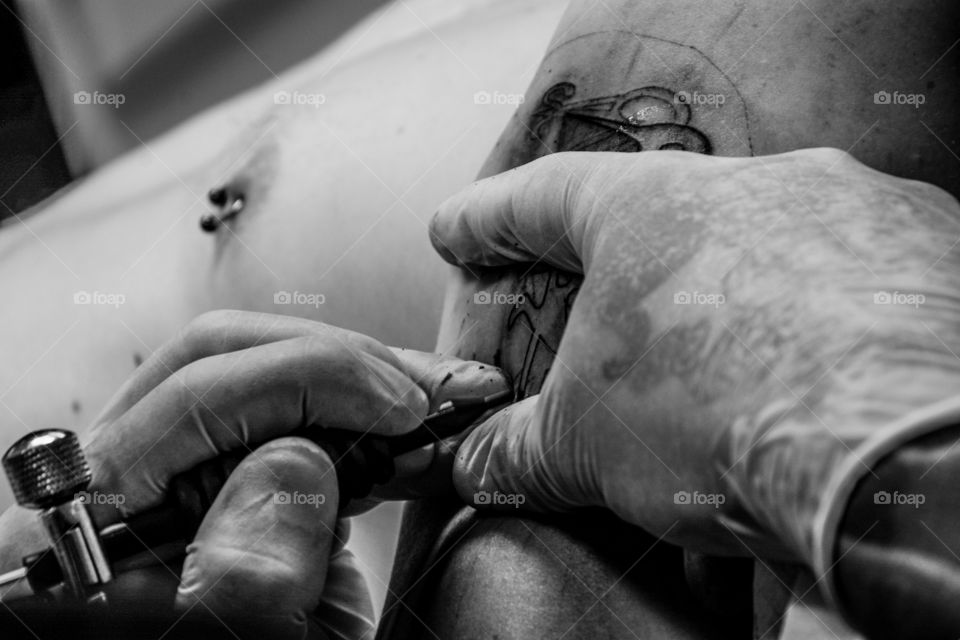 Hands of a tattoo artist that is creating magic on the skin