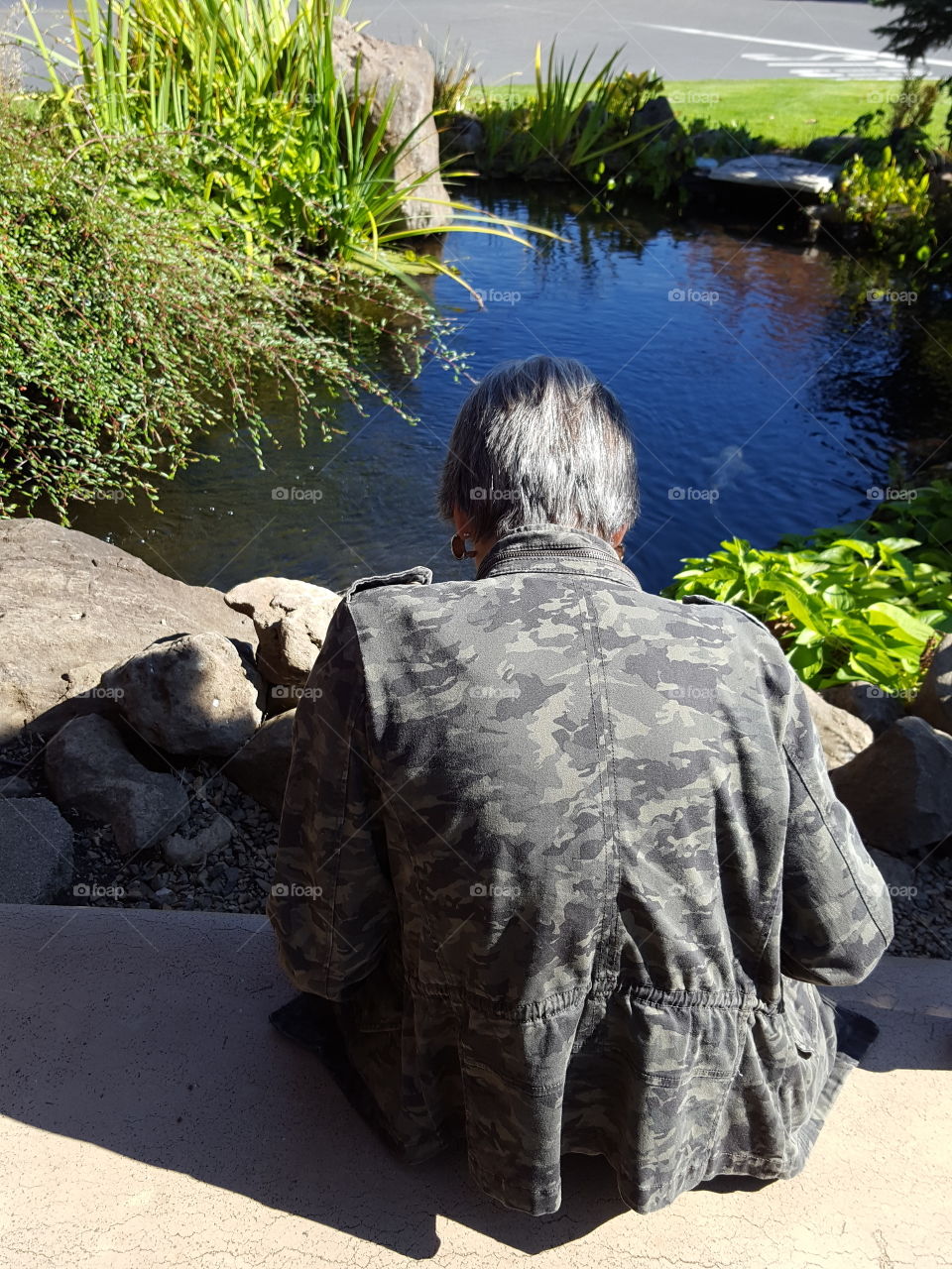 elder sitting by water