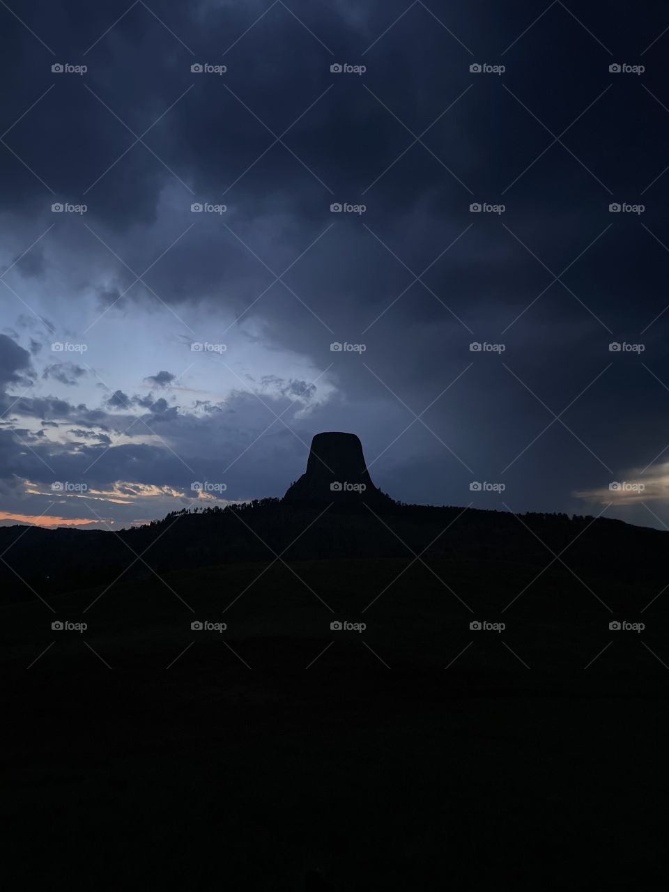 Devils tower dark nighttime nightfall Blue skies Colors cloudy gloomy sunset gray skies outline beautiful landscape views scenic