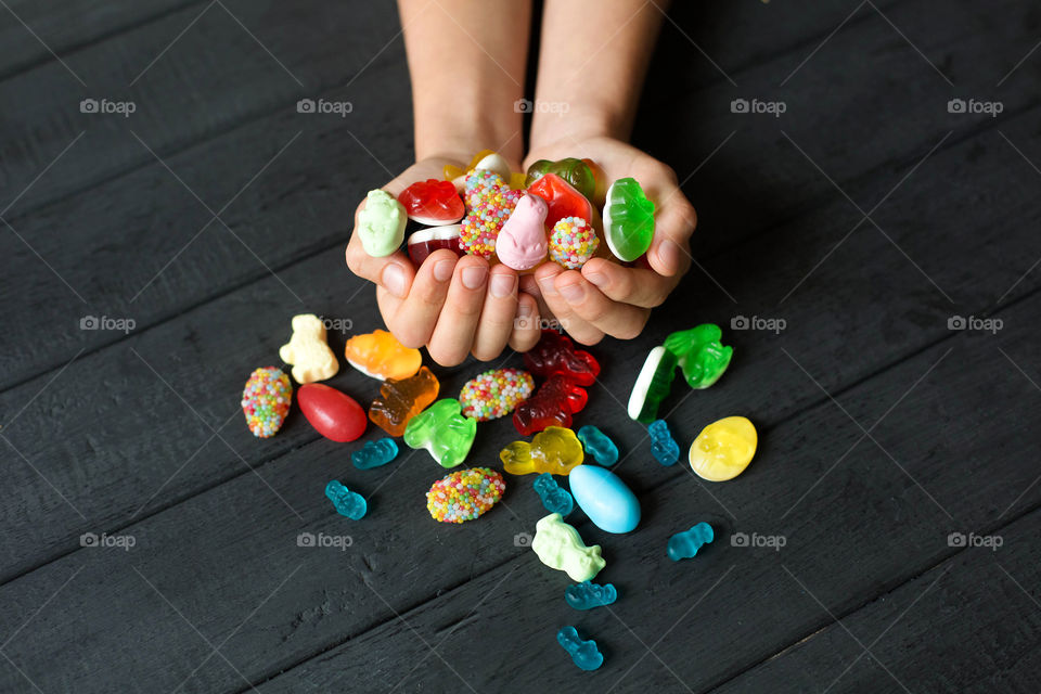 Colorful candies on human hand