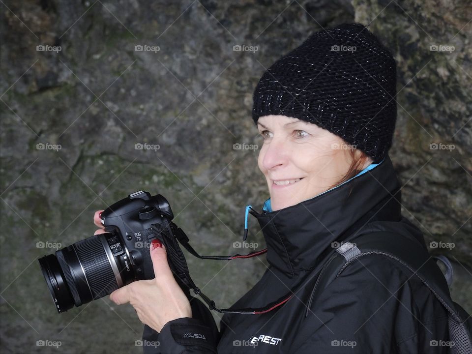 Close-up of a woman holding camera in hand