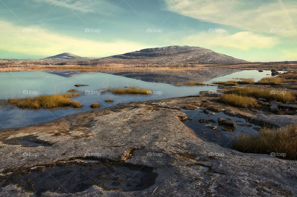 Beautiful morning landscape scenery with mountains reflected in Lake at Burren National Park in county Clare, Ireland