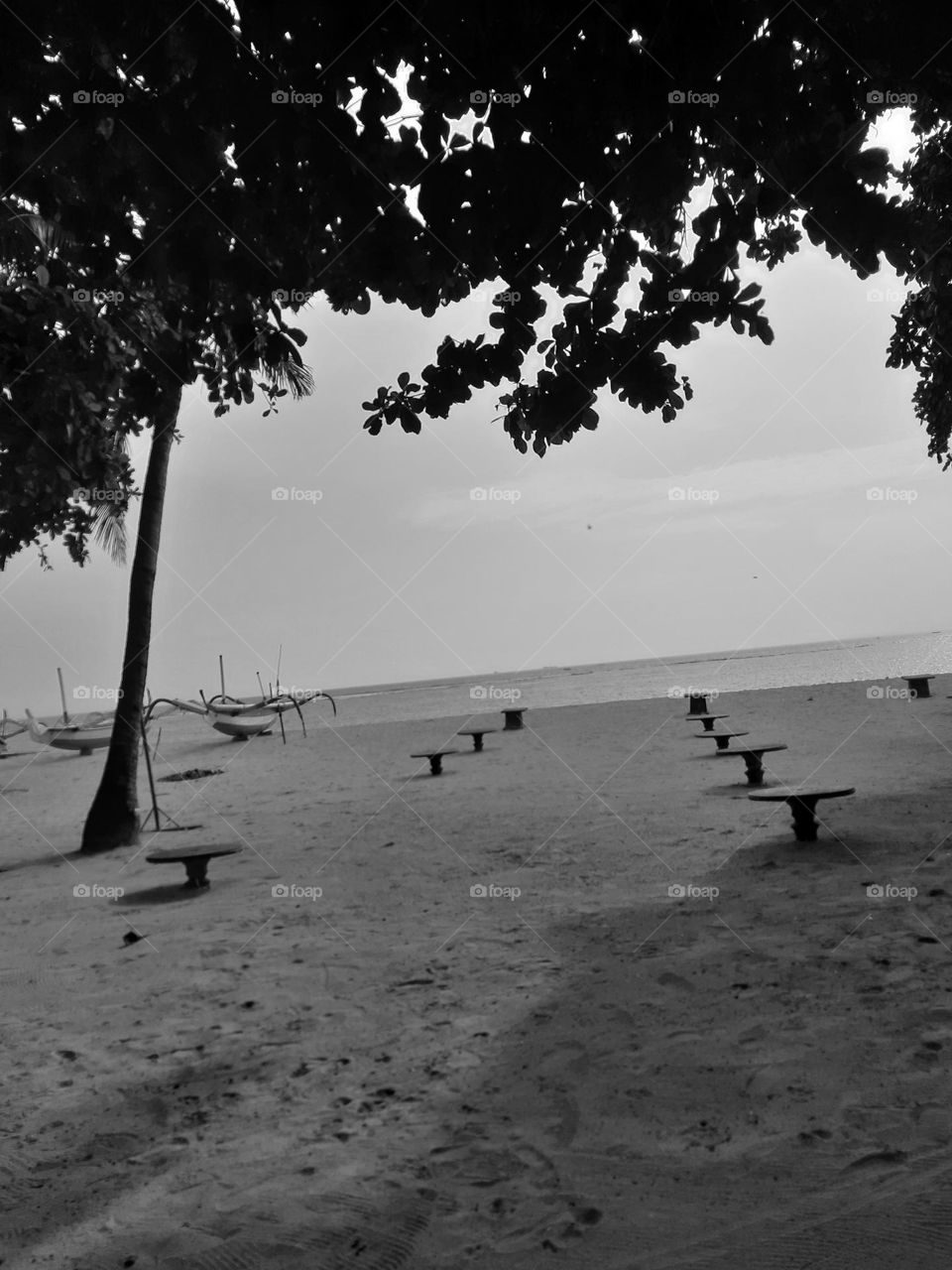 a fine art style of concrete round tables on the sandy beach