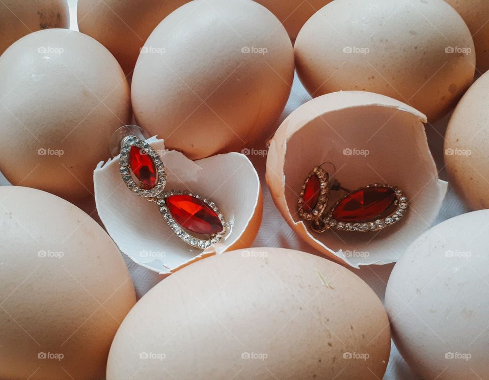 Earrings with red rubies among fragile eggs