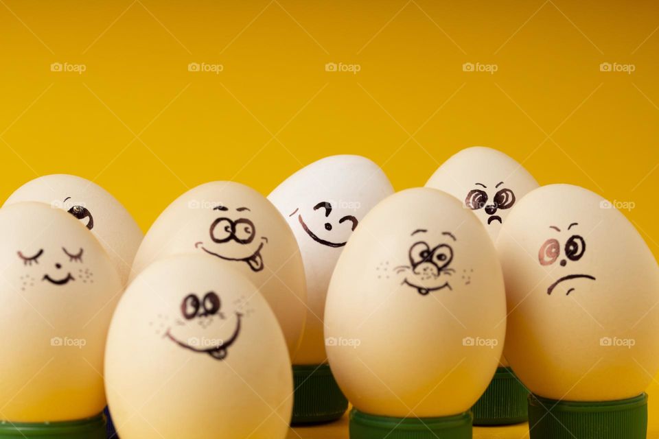 Funny smiling smileys eggs on yellow