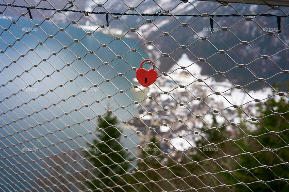 A heart-shaped padlock atttached to a metal bridge 