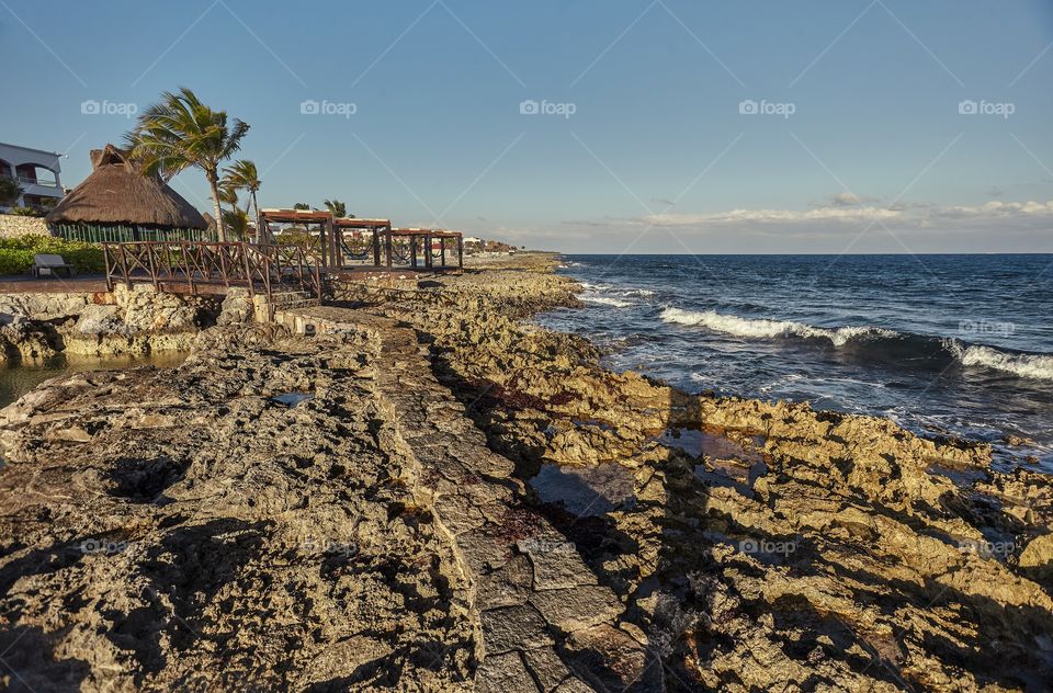 Beautiful natural rocky coast in the rocky coast at sunset in Puerto Aventuras in mexico.