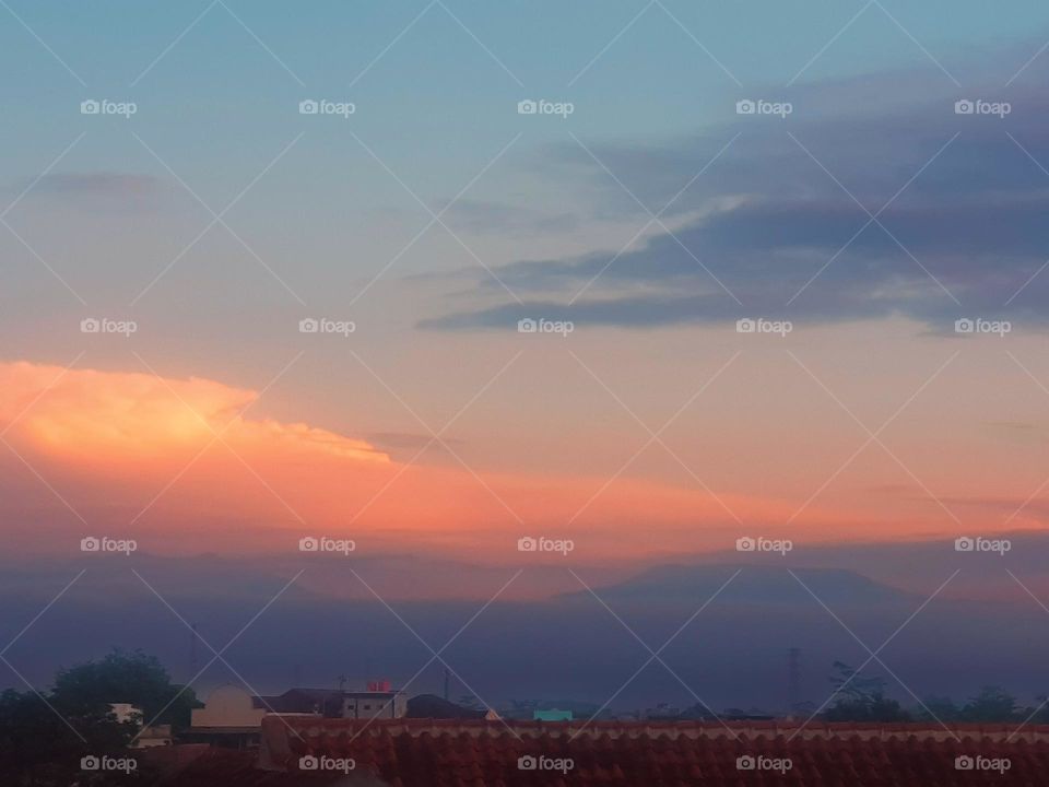 View in the morning, sky is cloudy and quite thick fog, sky is a little blue, the clouds look red, the air feels cold